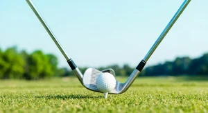 Best Golf Clubs: Two golf irons framing a golf ball on a tee, ready for a swing to improve iron contact and stop topping.